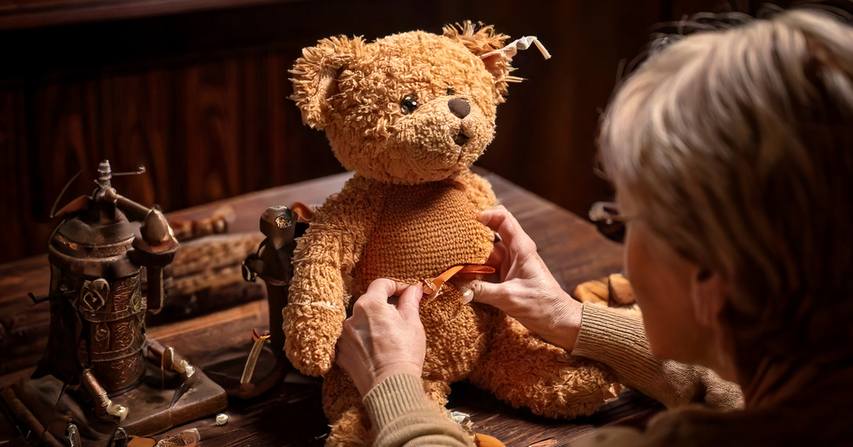 Eine Restauratorin arbeitet an einem alten Teddybär