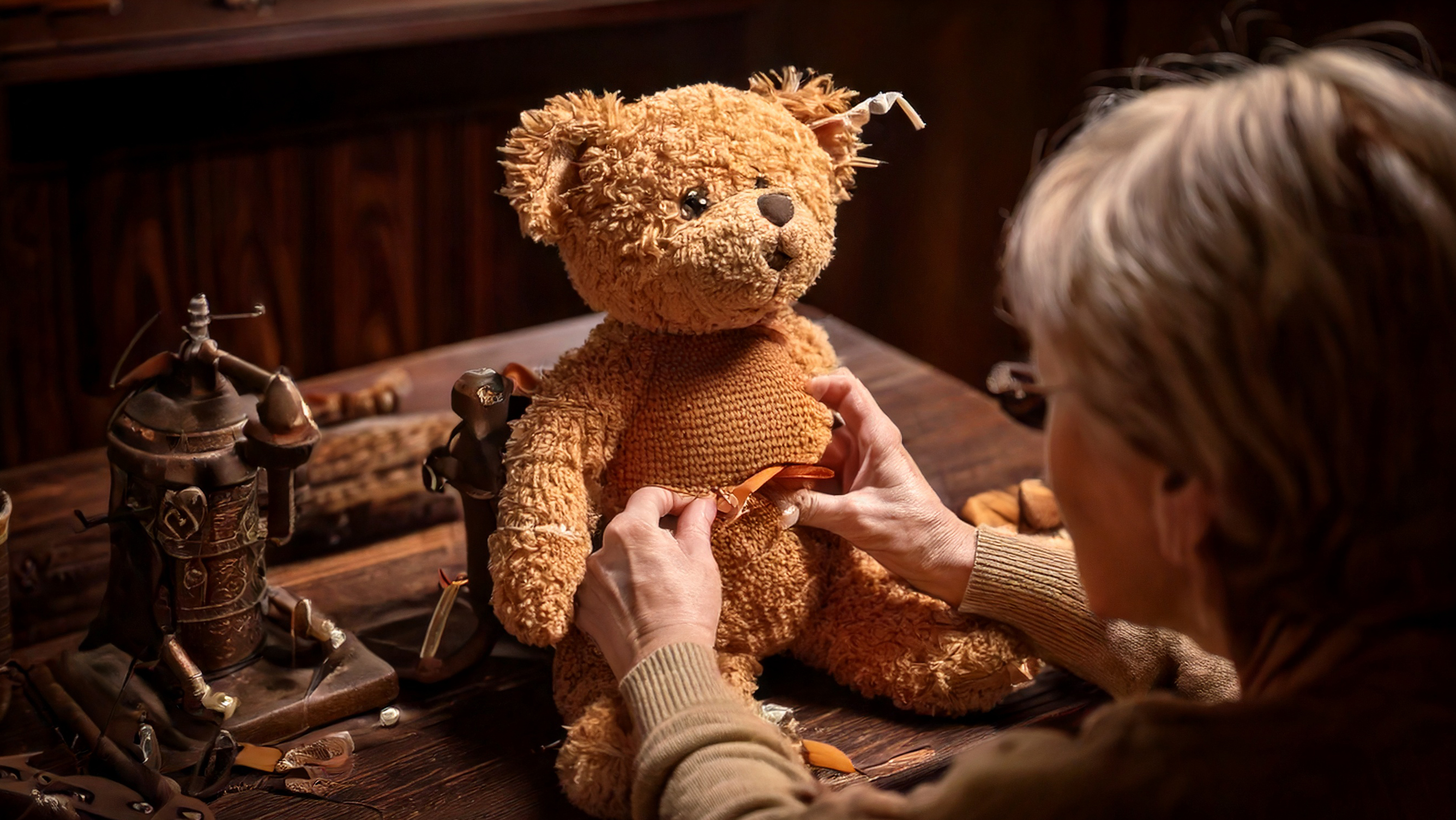 Eine Restauratorin arbeitet an einem alten Teddybär